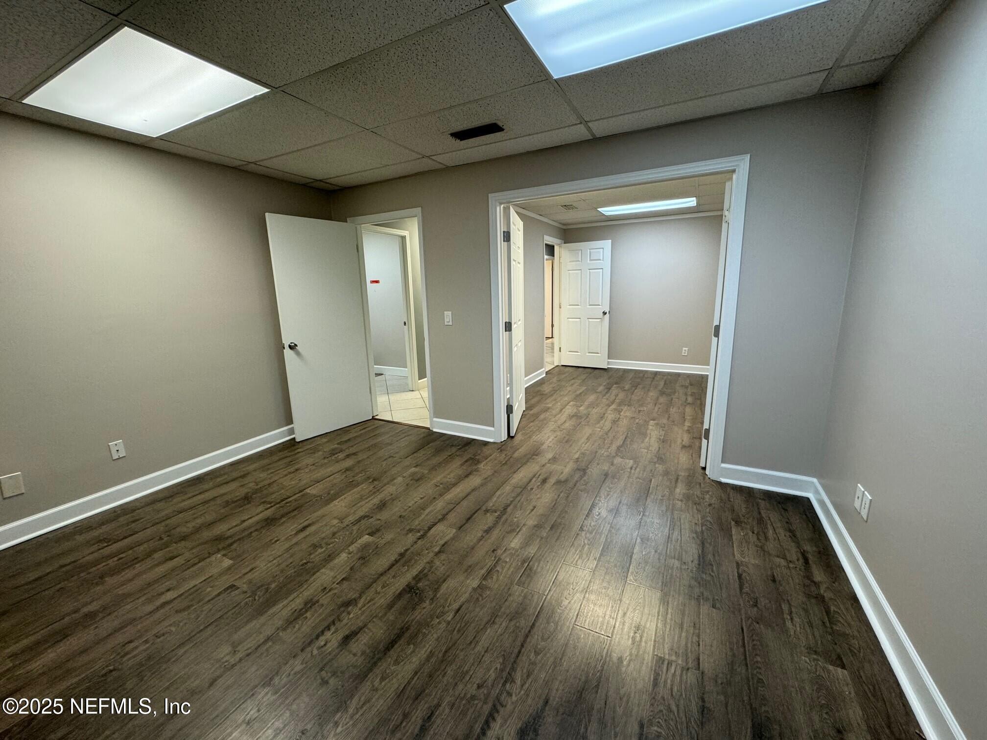 3938 Sunbeam Road Jacksonville, FL 32257 - Photo 19 of 28 an empty room with wooden floor and windows