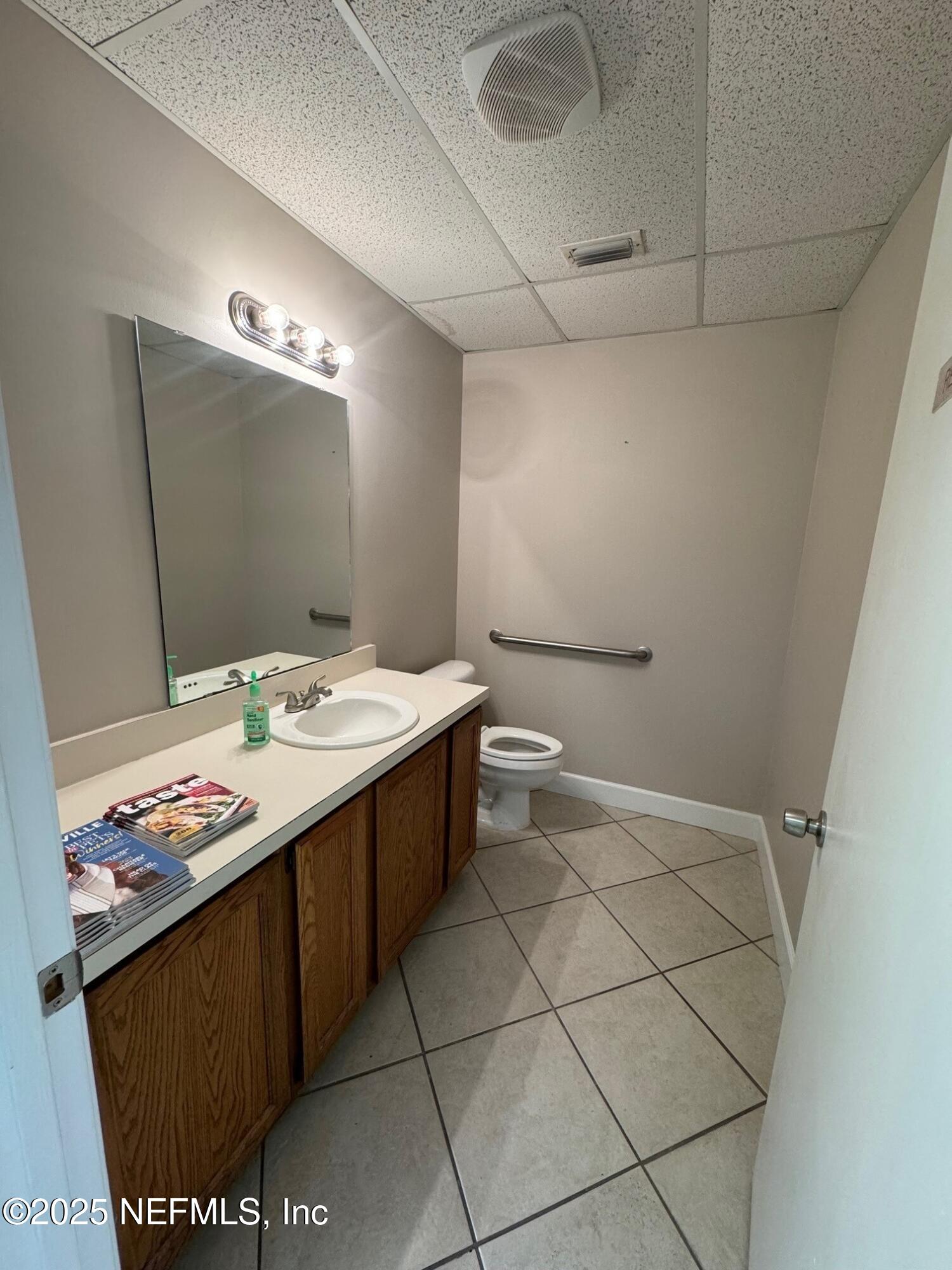 3938 Sunbeam Road Jacksonville, FL 32257 - Photo 22 of 28 a bathroom with a sink a toilet and mirror