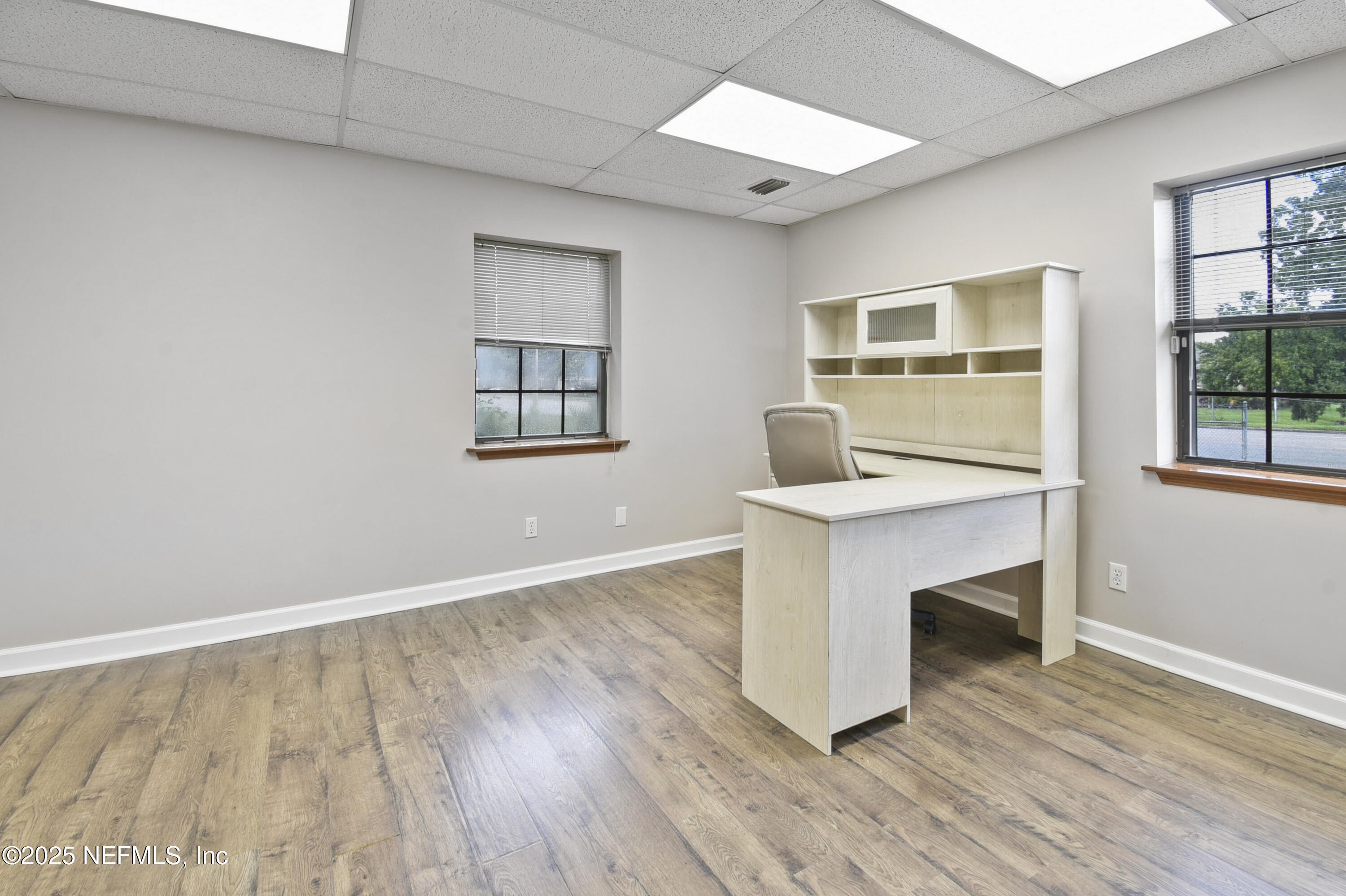 3938 Sunbeam Road Jacksonville, FL 32257 - Photo 5 of 28 an empty room with wooden floor and windows