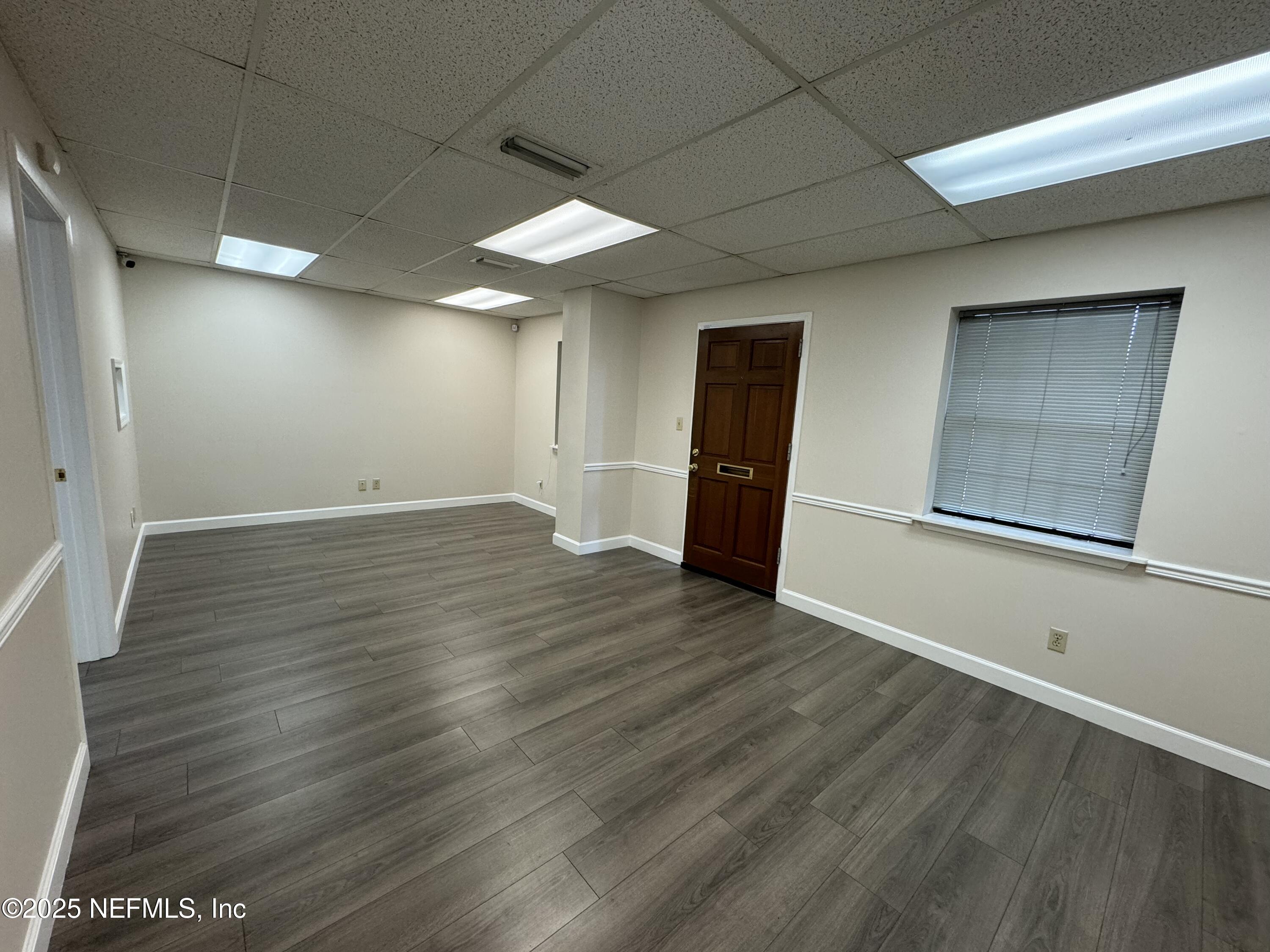 3938 Sunbeam Road Jacksonville, FL 32257 - Photo 10 of 28 an empty room with wooden floor and windows