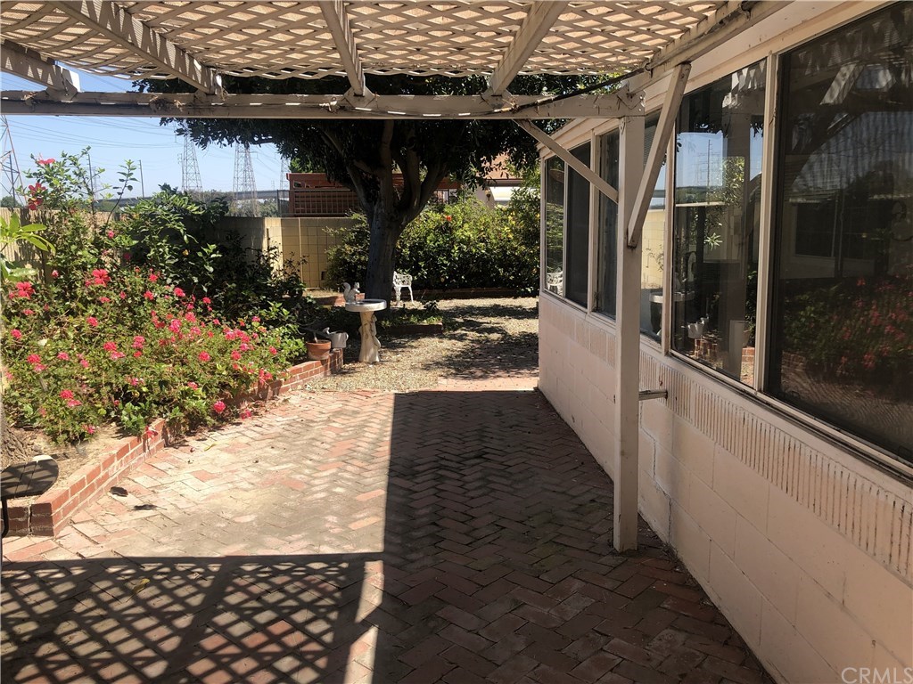 273 Harvard Lane Seal Beach, CA 90740 - Photo 20 of 43 View from the patio area that has the overhand to the opposite side of the yard. Block walls surround the yard.