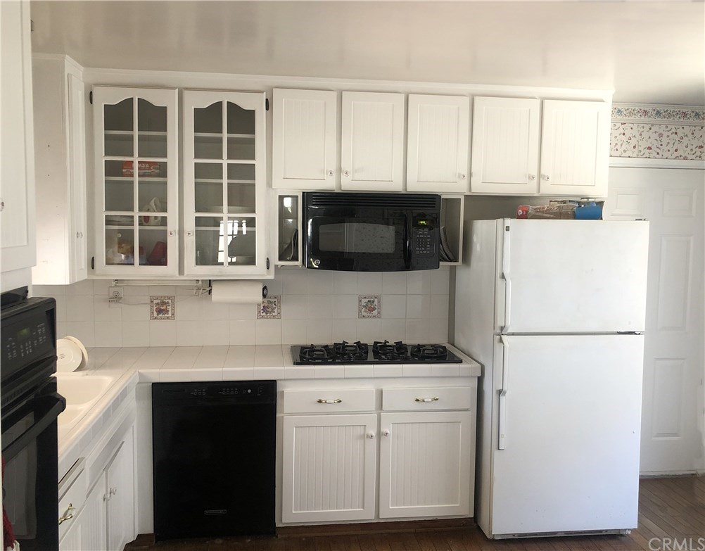 273 Harvard Lane Seal Beach, CA 90740 - Photo 4 of 43 Spacious and Sharp Looking Kitchen with White Shaker Cabinets and White Tile Counters.
