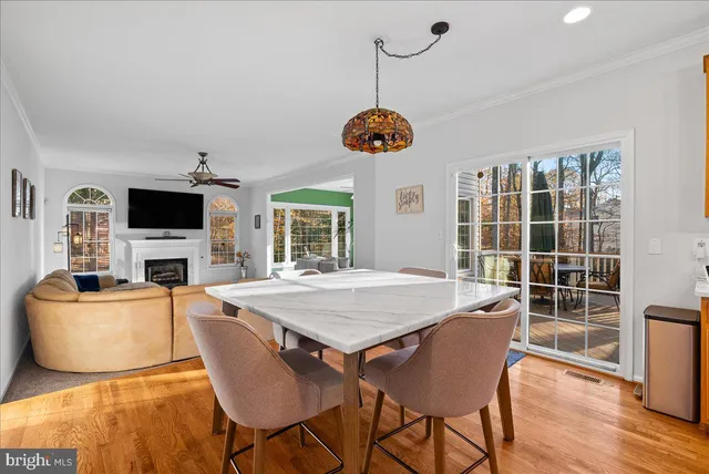 a view of a dining room with furniture a chandelier and wooden floor
