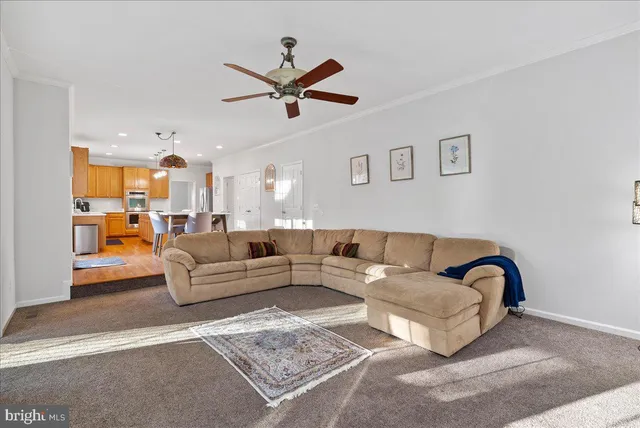 a living room with furniture a flat screen tv and a large window