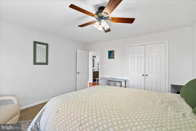 a bathroom with a granite countertop sink vanity mirror and toilet