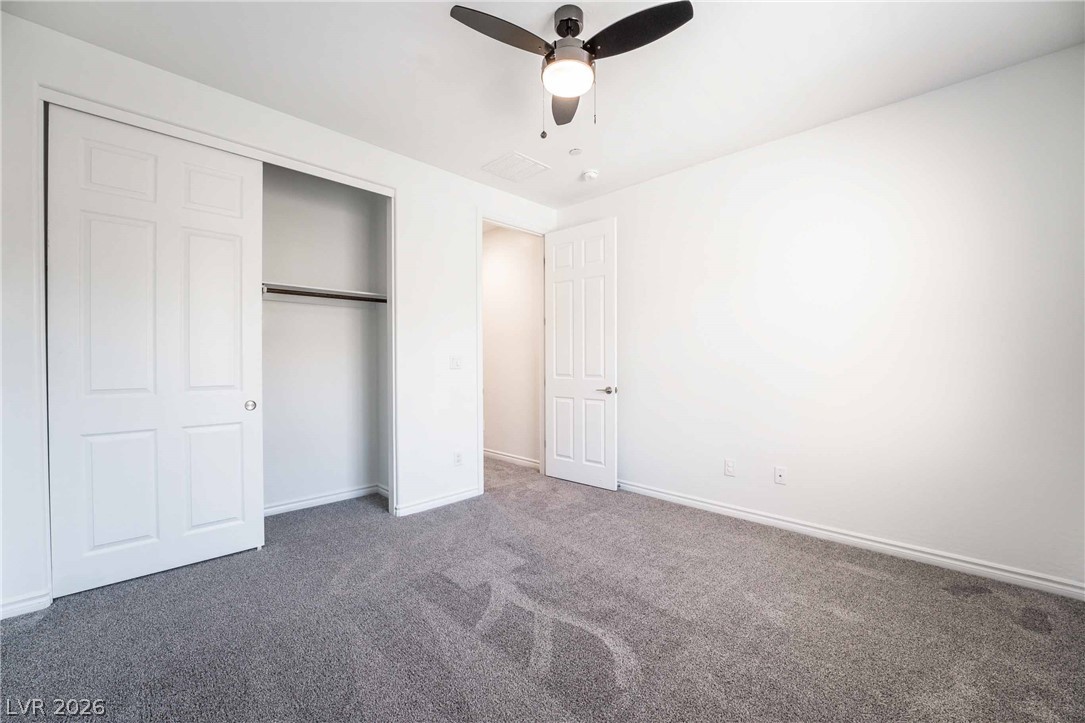 2787 Athens Ridge Drive Henderson, NV 89052 - Photo 22 of 31 A well-lit bedroom with fresh gray carpeting offers comfortable living.