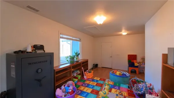 a room with toys and dresser with wooden floor