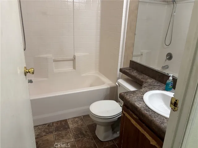 a bathroom with a granite countertop toilet sink and shower