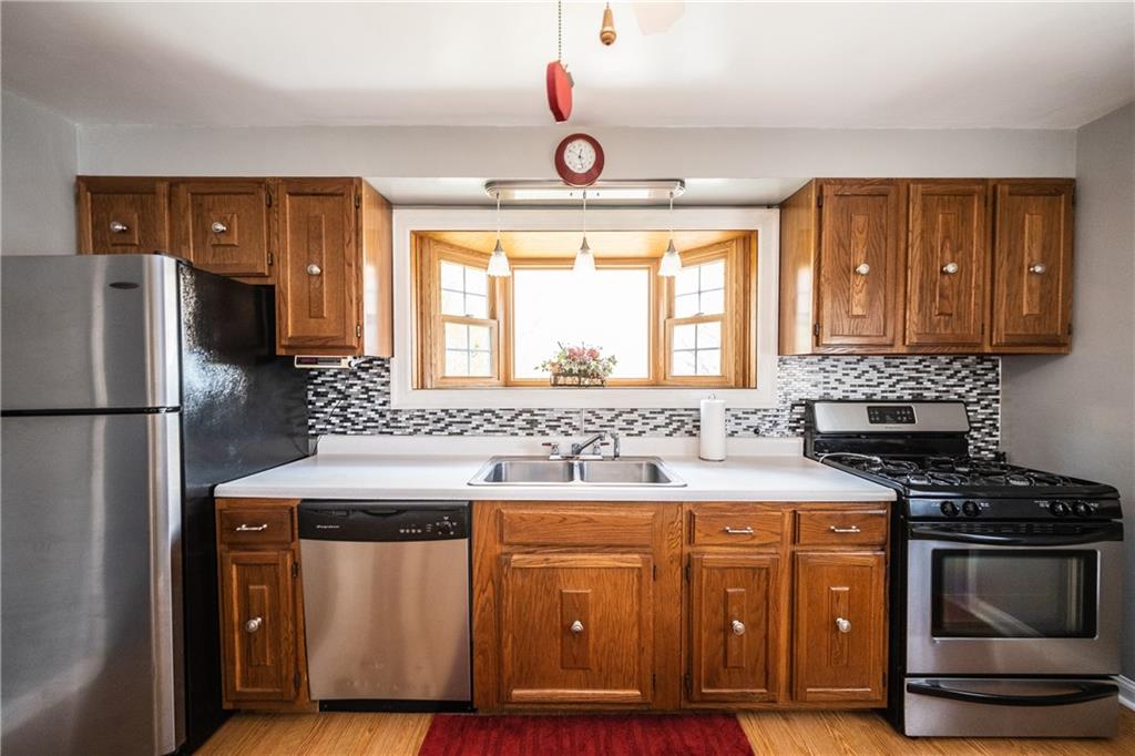 222 Ann Street McKees Rocks, PA 15136 - Photo 4 of 24 The kitchen has fresh cabinet hardware, SS appliances, glass tile backsplash, laminate hardwood floor & a garden/herb window.