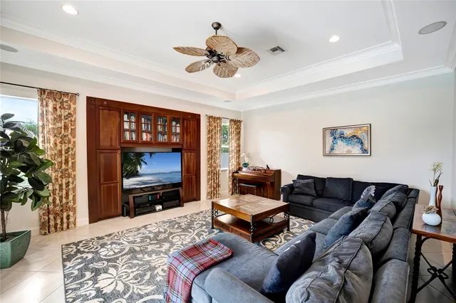 a living room with furniture a flat screen tv and a floor to ceiling window