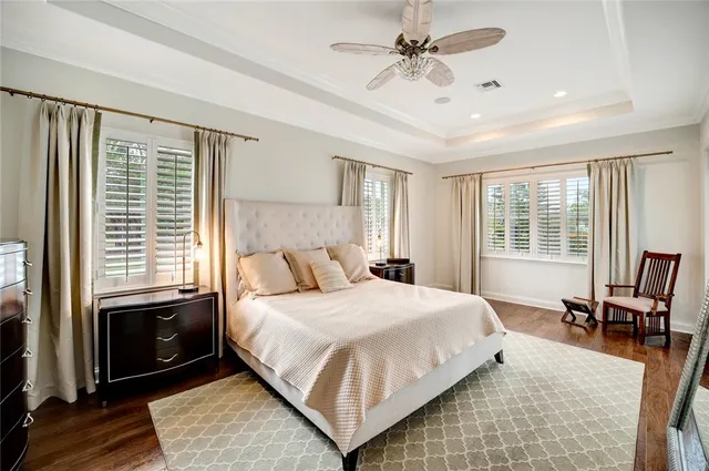 a bedroom with a large bed a rug and windows