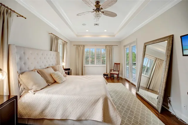 a bedroom with a bed and a large mirror next to a window