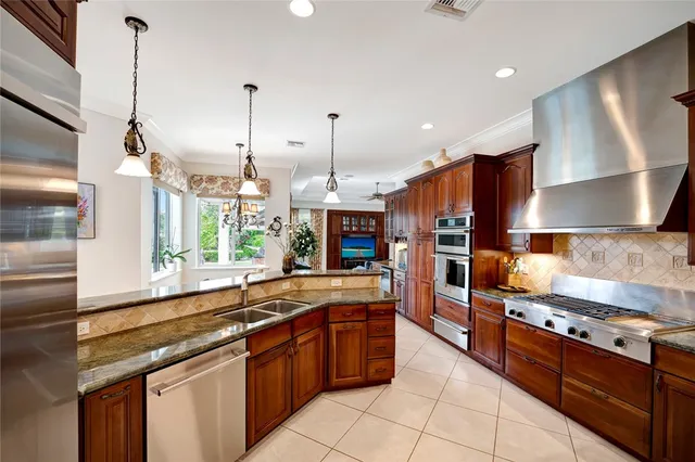 a kitchen with stainless steel appliances granite countertop a stove a sink and a refrigerator