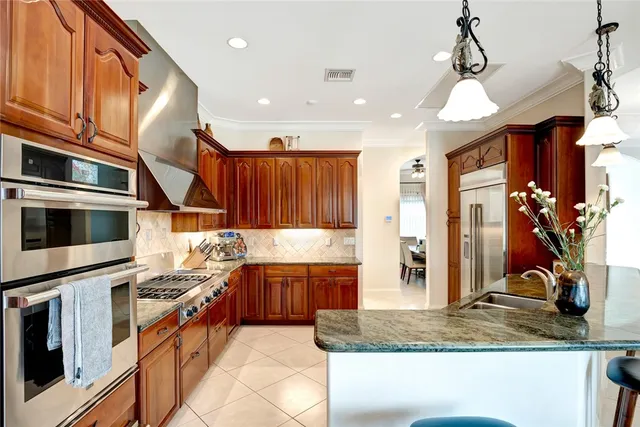 a kitchen with stainless steel appliances granite countertop a sink and a stove