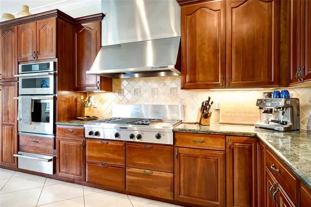 a kitchen with stainless steel appliances granite countertop wooden cabinets a stove top oven a sink and dishwasher