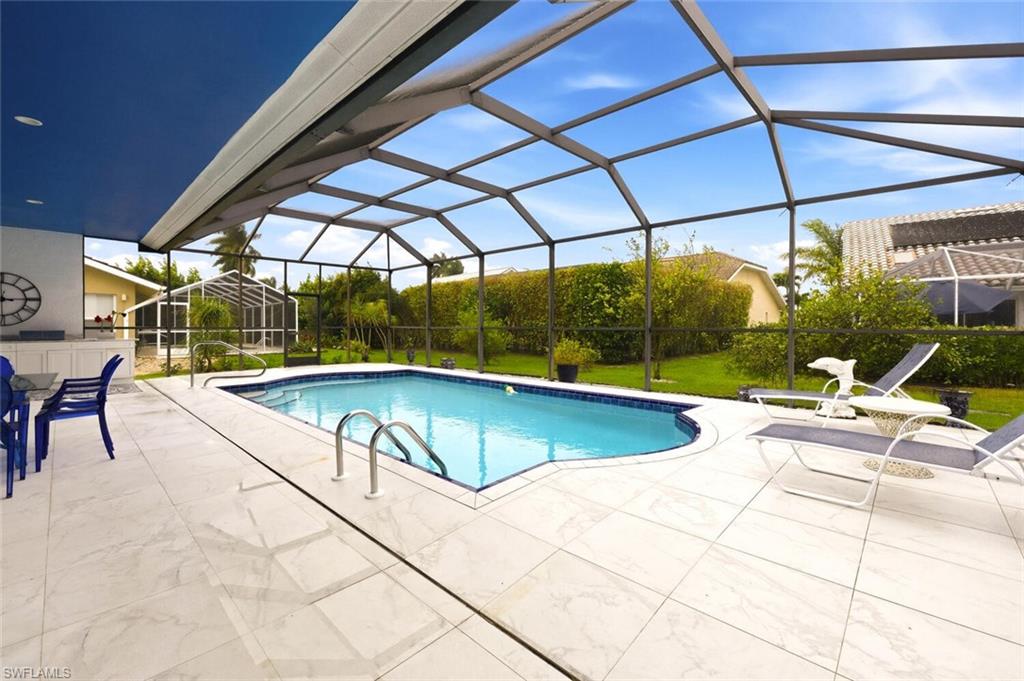209 Countryside Drive Naples, FL 34104 - Photo 31 of 50 Outdoor pool with a sunroom, a lanai, a patio, and a lawn