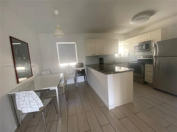 a kitchen with granite countertop a sink a counter space and stainless steel appliances