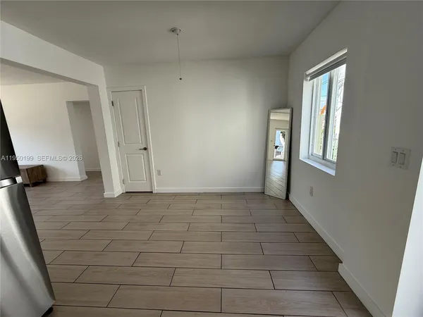 a view of an empty room and a bathroom