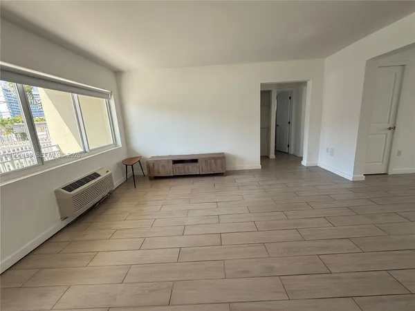 a view of a room with wooden floor and a ceiling fan