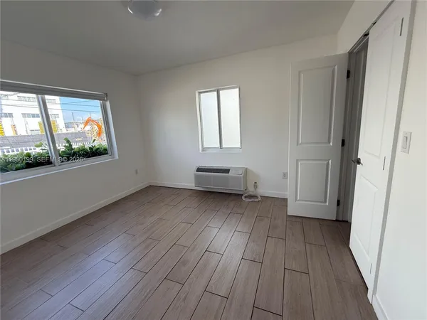 an empty room with windows and closet