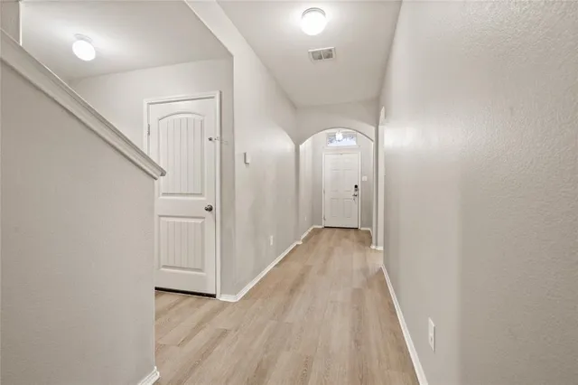 a living room with furniture kitchen view and a chandelier