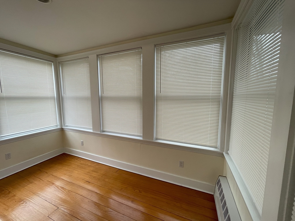 22 Walnut Place, Unit 1 Newton, MA 02460 - Photo 5 of 15 a view of an empty room with a window and wooden floor