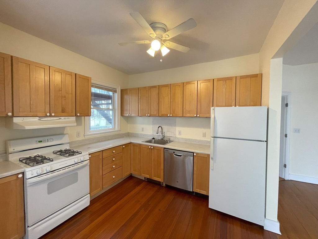 22 Walnut Place, Unit 1 Newton, MA 02460 - Photo 8 of 15 a kitchen with cabinets stainless steel appliances a sink and wooden floor
