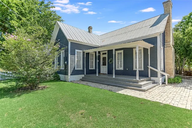 a view of a house with backyard and porch