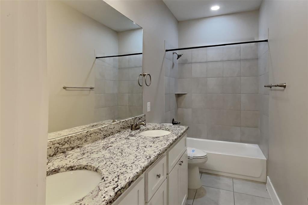 237 Giddings Trail Forney, TX 75126 - Photo 15 of 18 a bathroom with a granite countertop sink a toilet and shower