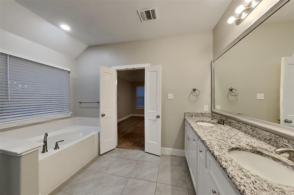 237 Giddings Trail Forney, TX 75126 - Photo 8 of 18 a spacious bathroom with a granite countertop tub sink and mirror