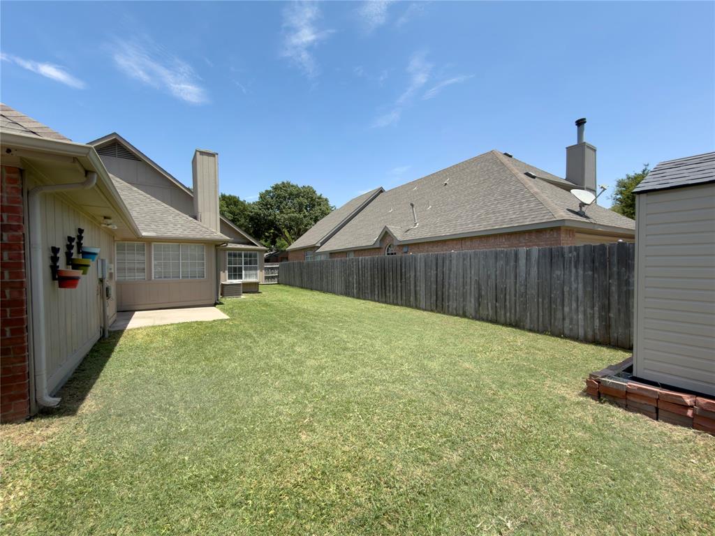 4234 Timberglen Road Dallas, TX 75287 - Photo 27 of 32 Expansive backyard featuring a manicured lawn, a concrete patio, and a privacy fence