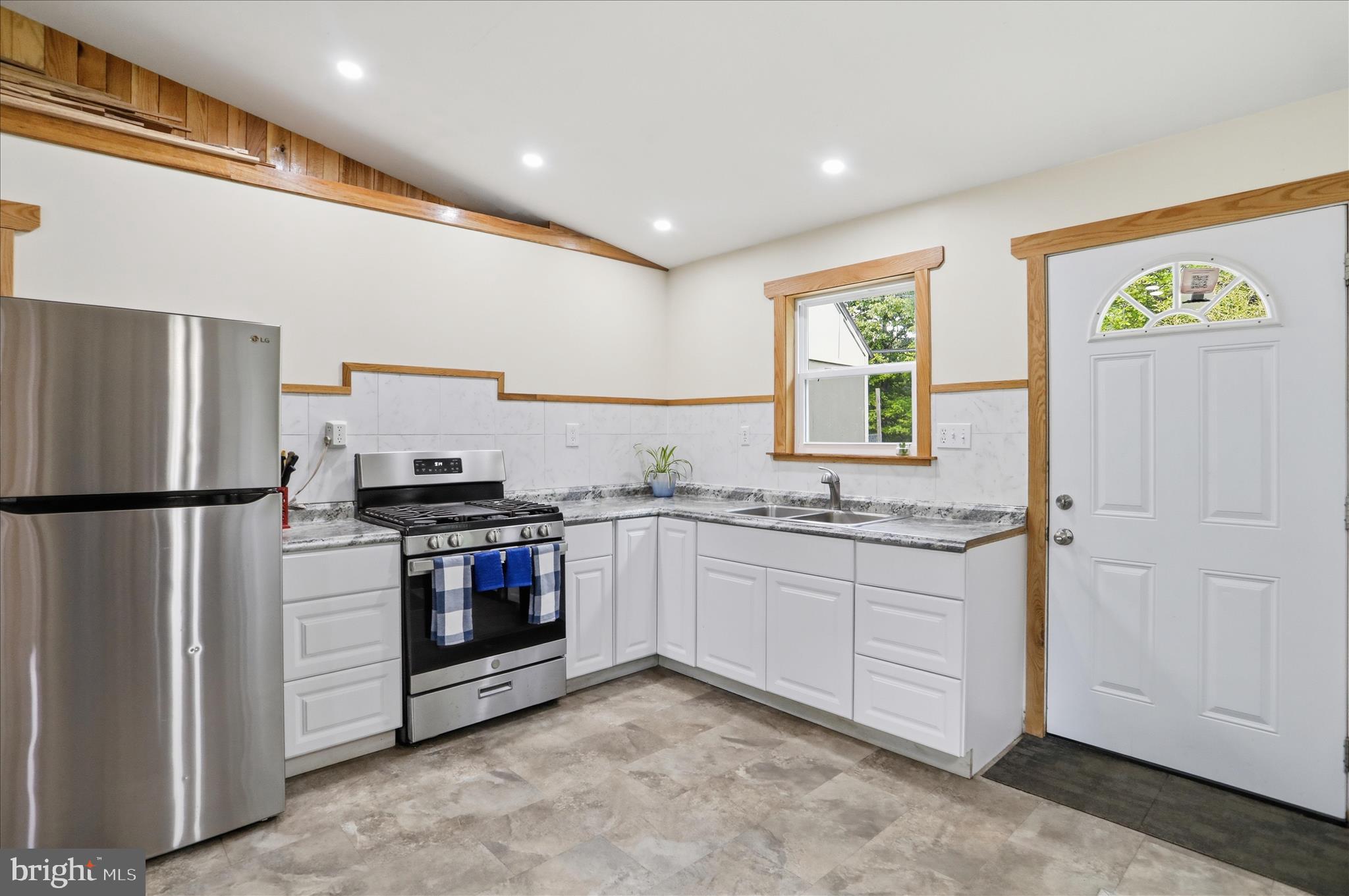 936 Johnny Cake Road Great Cacapon, WV 25422 - Photo 9 of 33 a kitchen with stainless steel appliances granite countertop a refrigerator and a sink