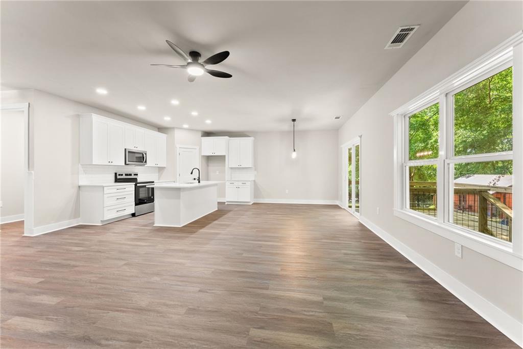 43 Anderson Street Jefferson, GA 30549 - Photo 13 of 45 a view of an empty room with wooden floor and a kitchen
