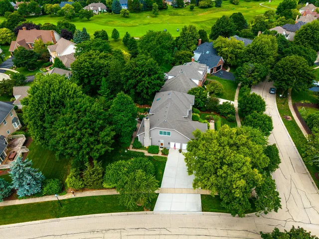 an aerial view of a house with a yard and lake view