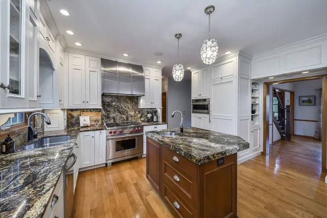 a large kitchen with granite countertop a stove oven and a sink with granite countertops