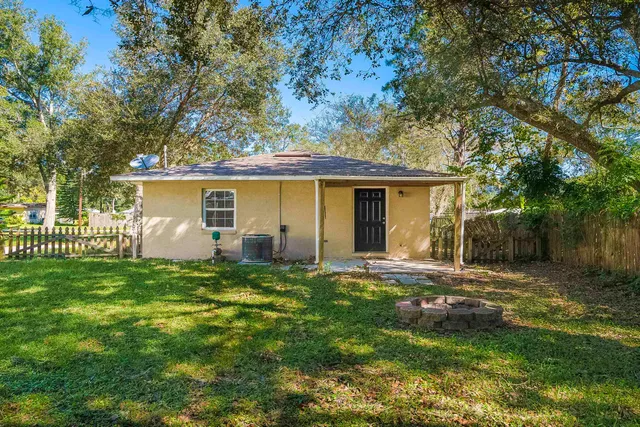 a view of a house with a yard and fence