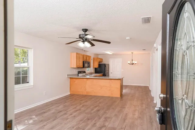 a view of a living room with wooden floor and a ceiling fan