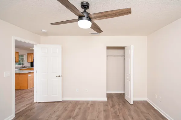 a view of empty room with wooden floor