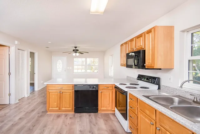 a kitchen with stainless steel appliances granite countertop a sink stove and cabinets