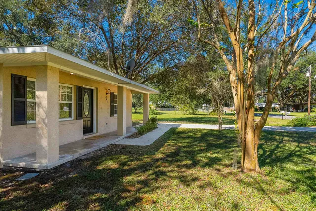 a view of a house with backyard and sitting area