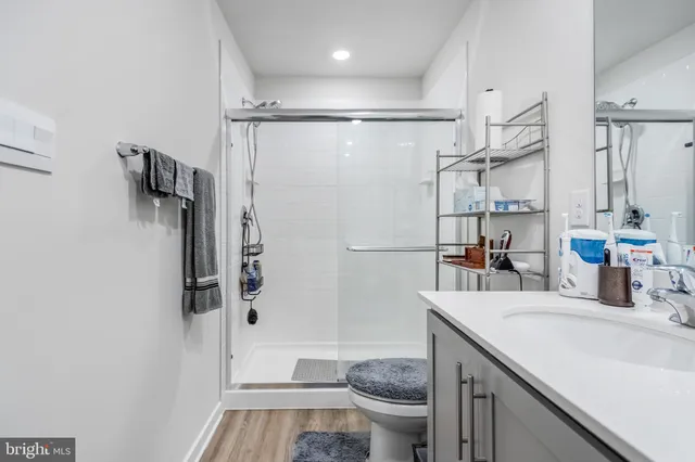 a bathroom with a granite countertop sink toilet and shower