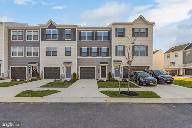 a view of a brick house with a yard in front of it