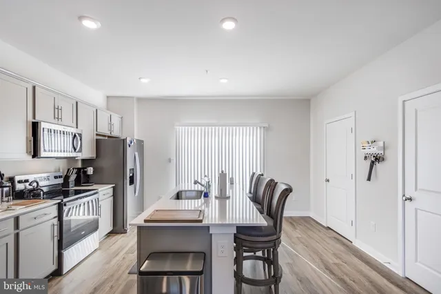 a kitchen with granite countertop a refrigerator and a stove top oven