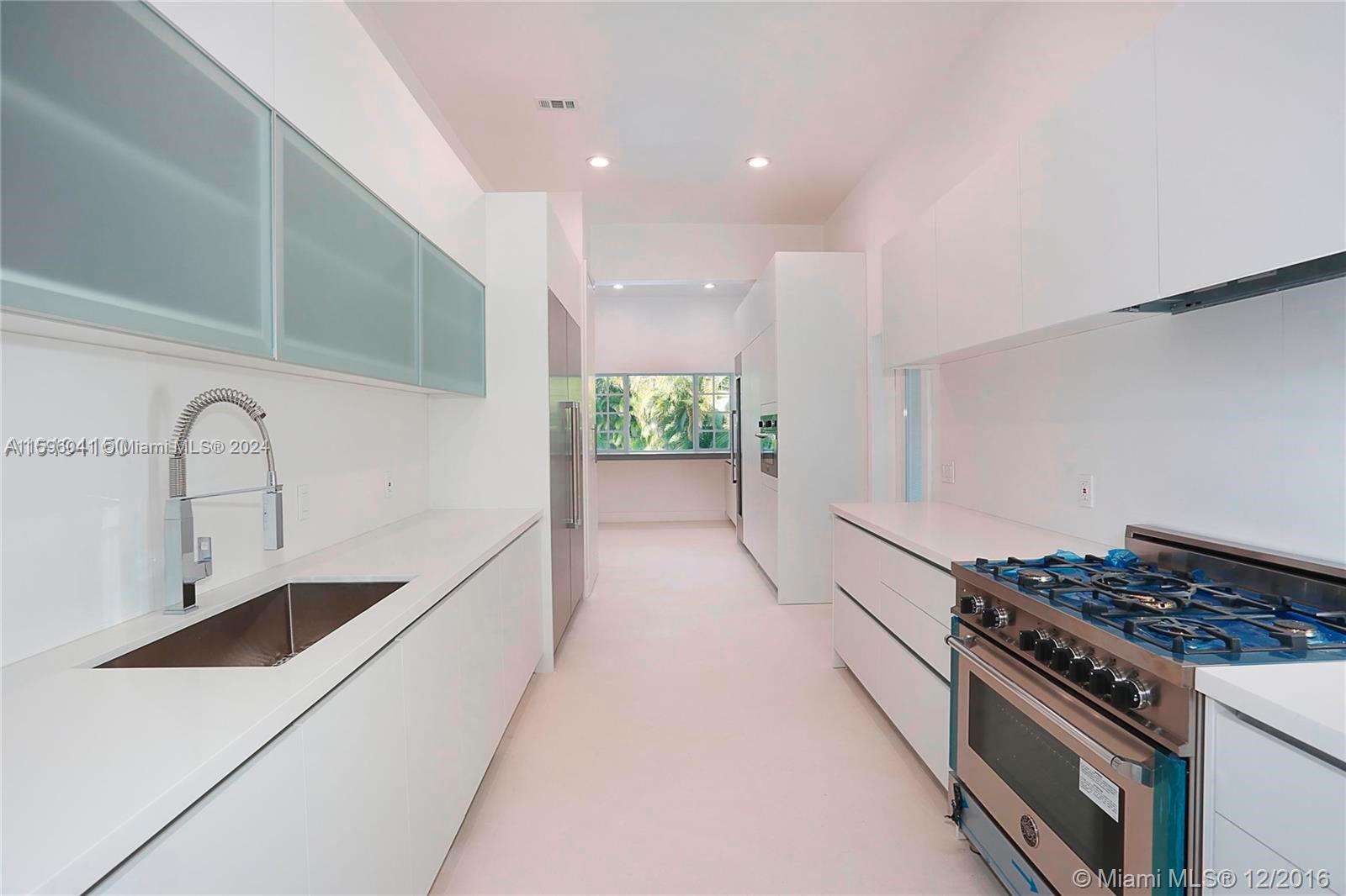 390 Gulf Road Key Biscayne, FL 33149 - Photo 15 of 25 a kitchen with stove and white cabinets