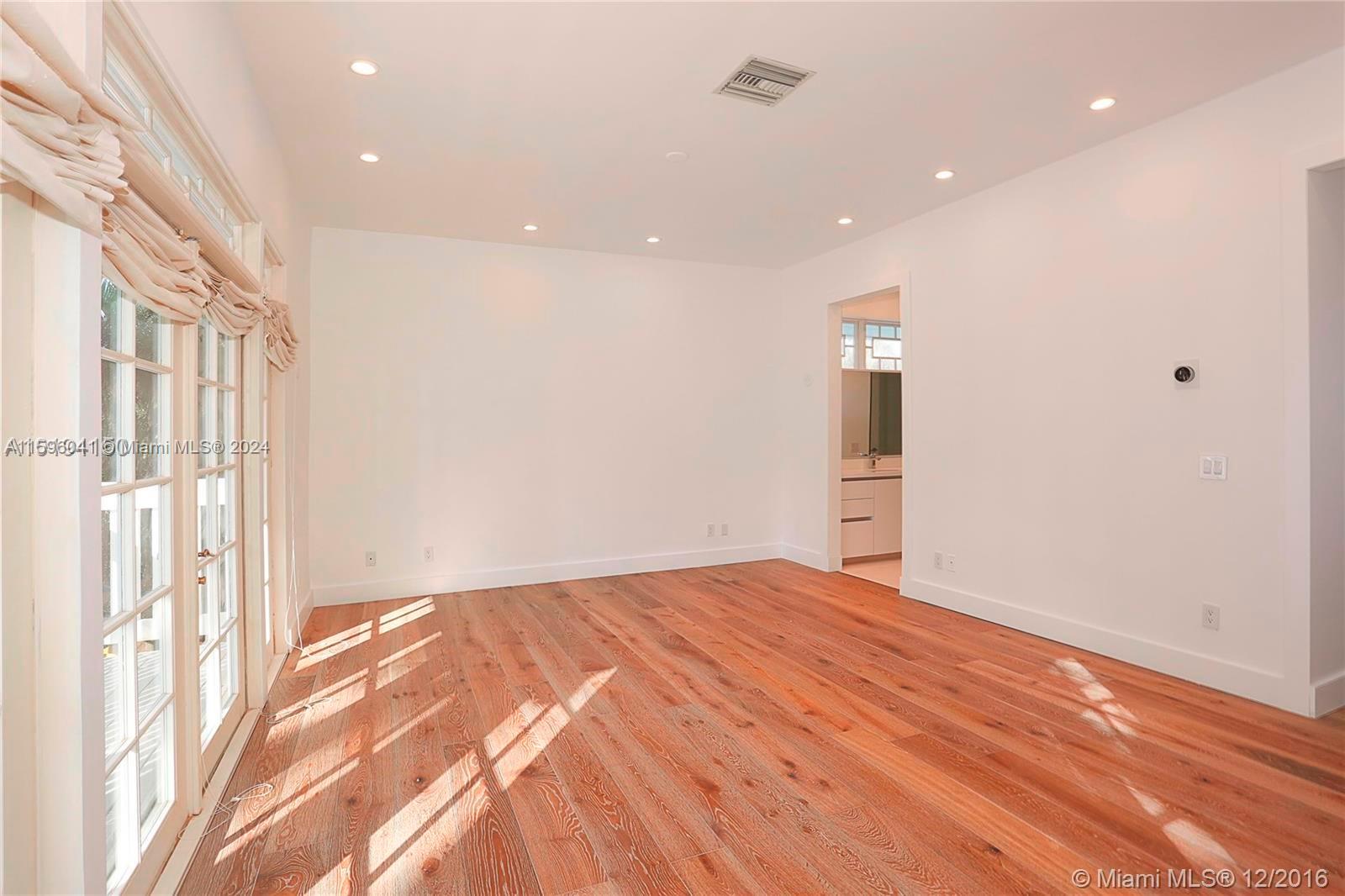 390 Gulf Road Key Biscayne, FL 33149 - Photo 20 of 25 a view of an empty room with wooden floor and a window