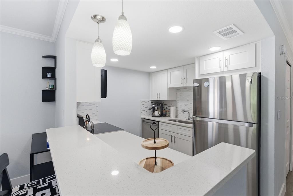 631 North Keene Road, Unit S8 Clearwater, FL 33755 - Photo 4 of 20 a kitchen with refrigerator and cabinets