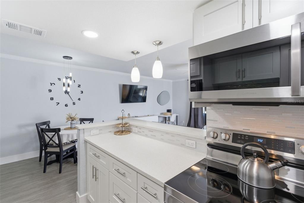 631 North Keene Road, Unit S8 Clearwater, FL 33755 - Photo 7 of 20 a kitchen with a sink and a stove top oven with wooden floor