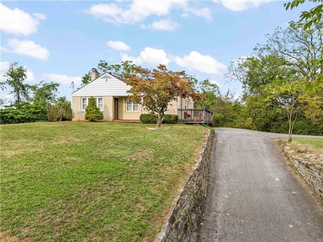 a view of a house with a yard and pathway