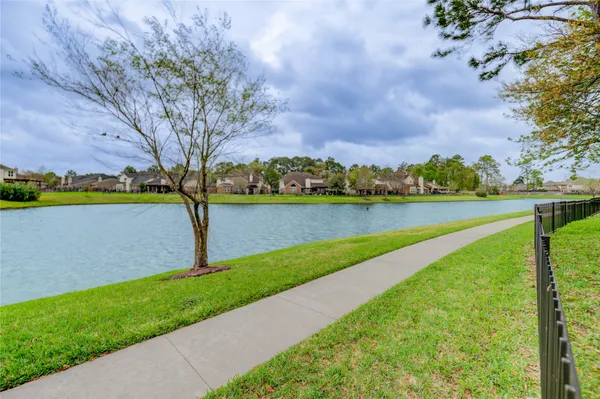 a view of a lake with a big yard and large trees