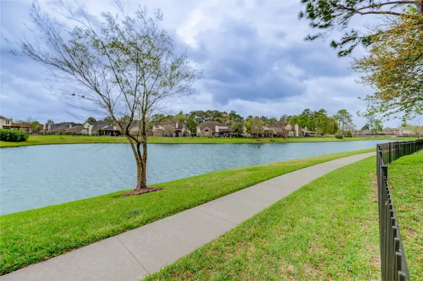 a view of a lake with a big yard and large trees